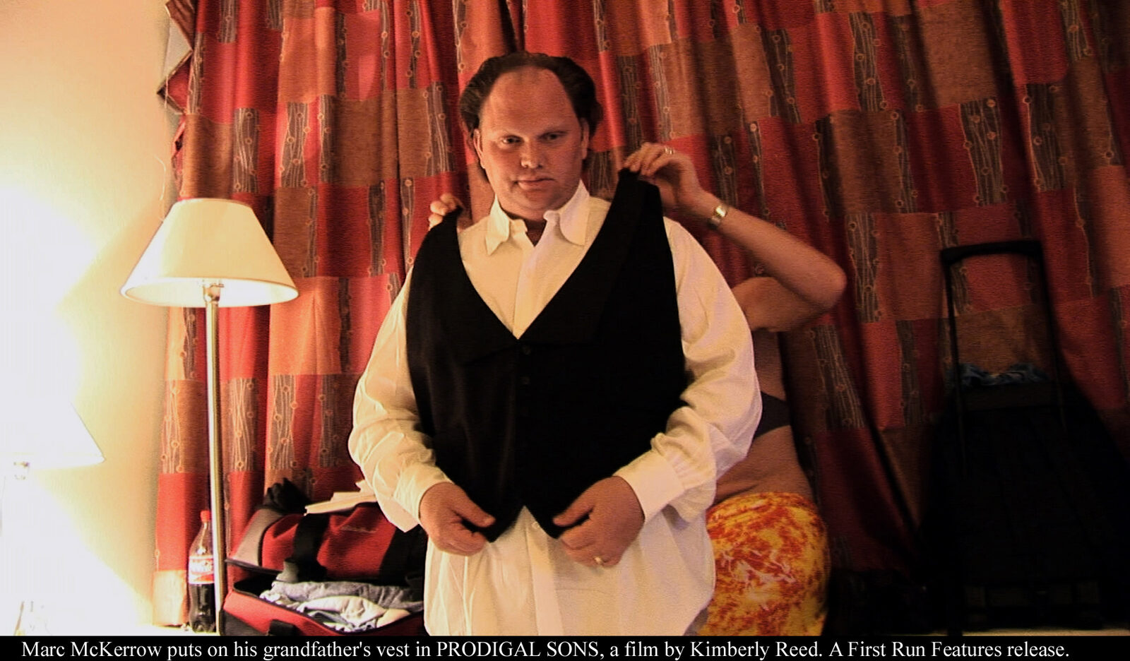 Marc McKerrow puts on his grandfather's vest — still from PRODIGAL SONS, a film by Kimberly Reed. A First Run Features release.